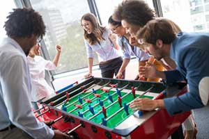 coworkers playing foosball during team building events